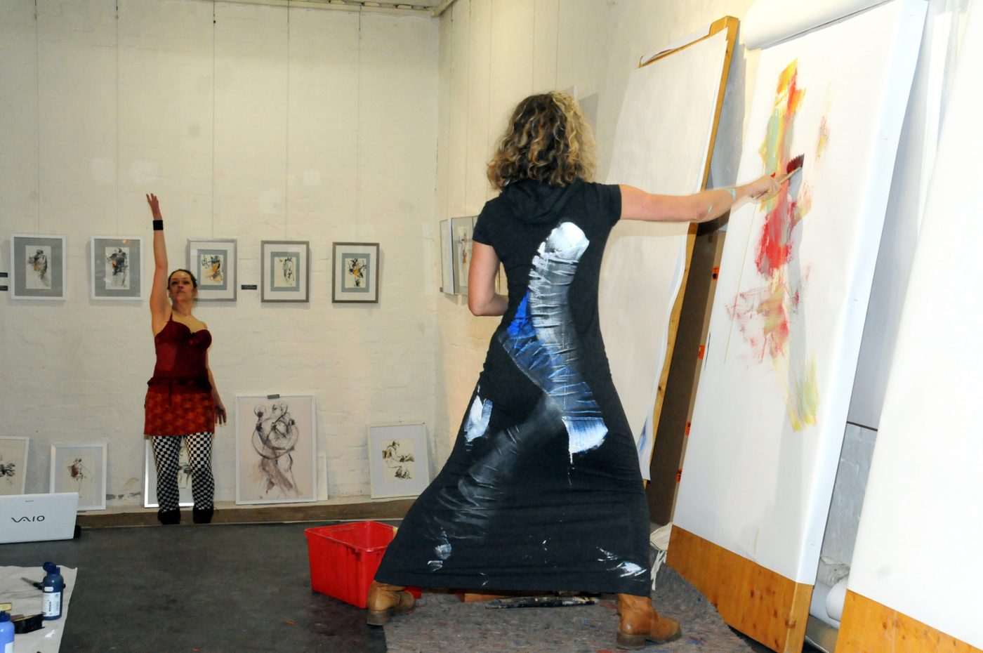 Isabella Moog malt tanzend an einer großen Leinwand